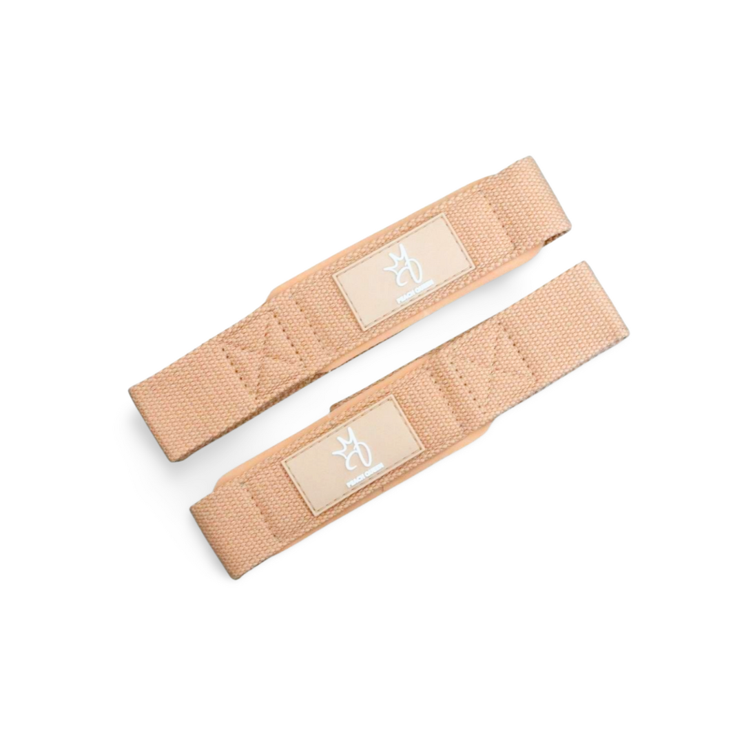 Two beige lifting straps with labels on a white background