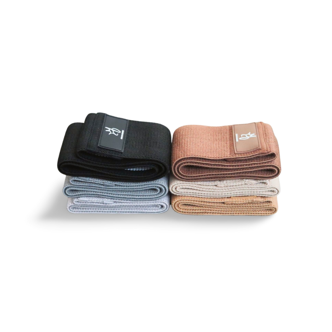 Stack of folded resistance bands in black, blue, and brown with visible brand logos on a white background