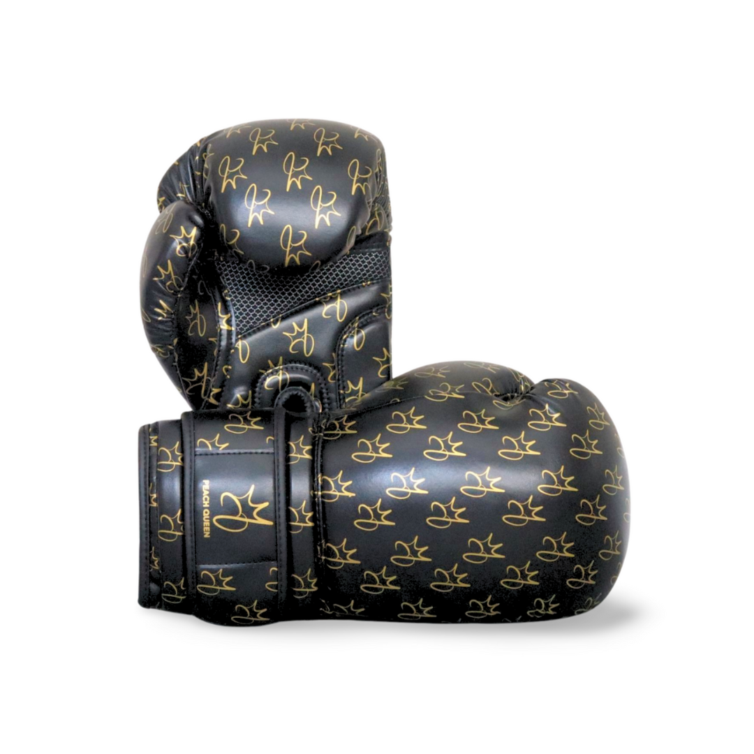 Black boxing gloves with gold logos on a white background