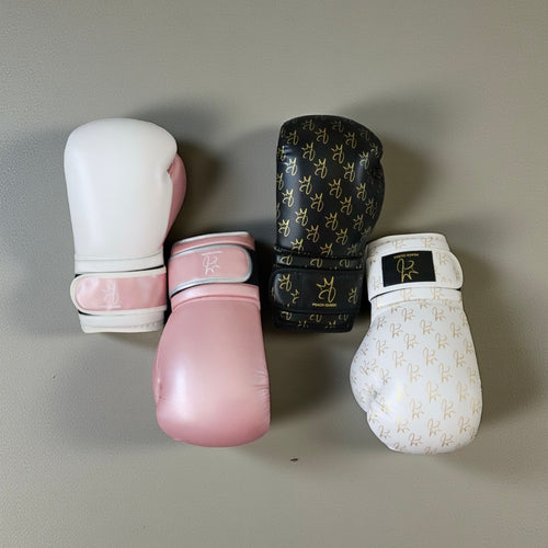 Four pairs of boxing gloves in different colors on a gray background