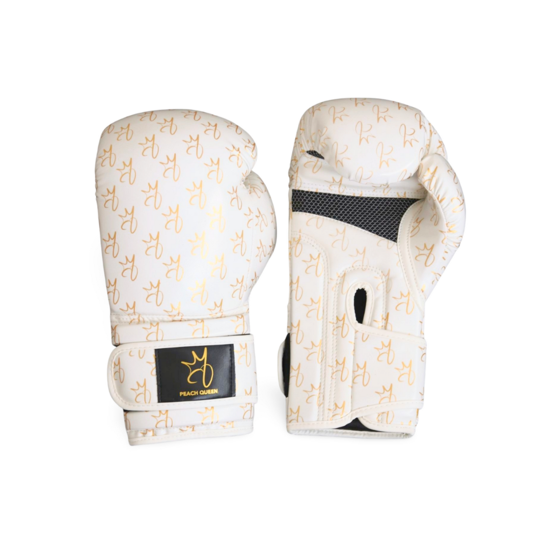 Pair of white boxing gloves with gold patterns on a white background