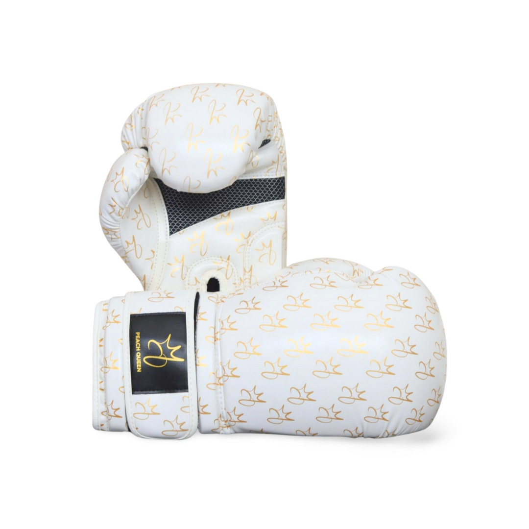 White boxing gloves with gold patterns and a brand logo on a white background
