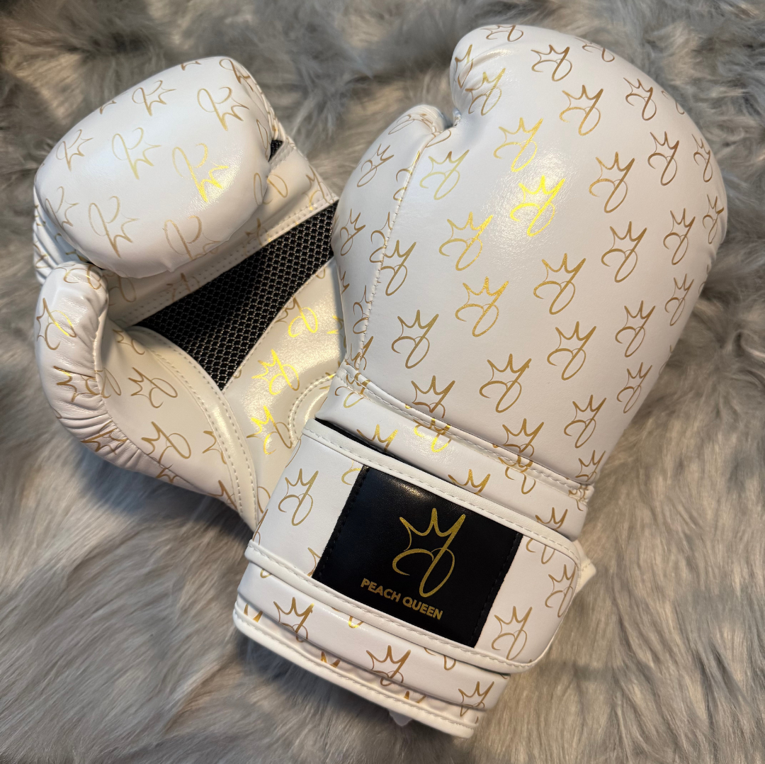 White boxing gloves with gold patterns on a gray fur background